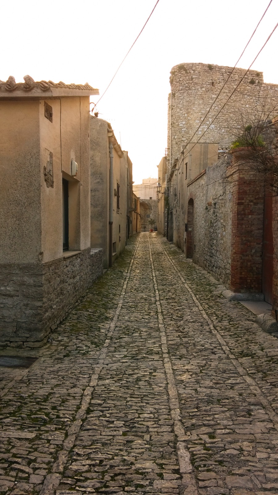 Cobblestone street climbing through the historic village of Erice in Sicily