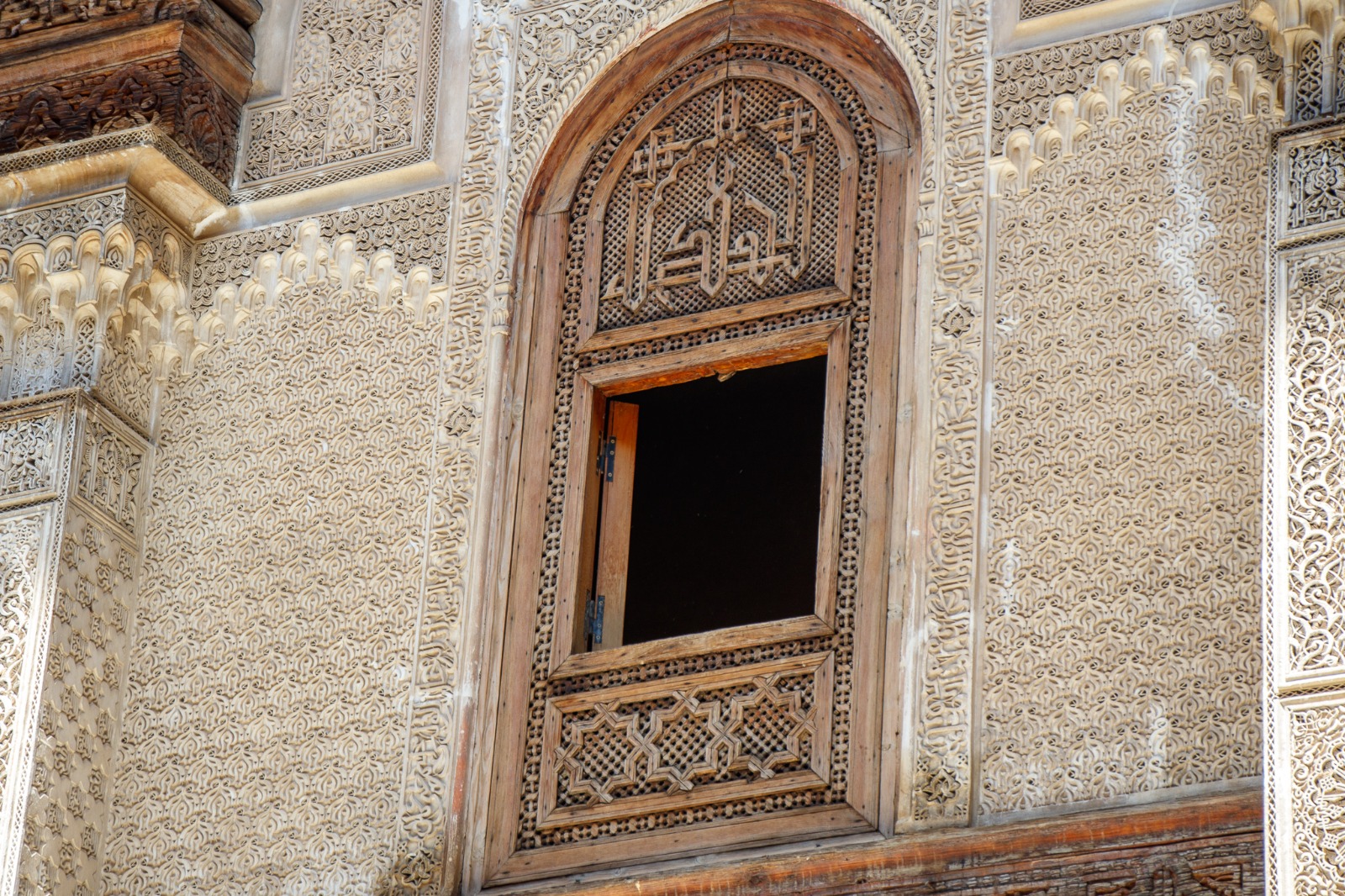 Carved stucco and wooden window inside Al Attarine Madrasa in Fes, Morocco