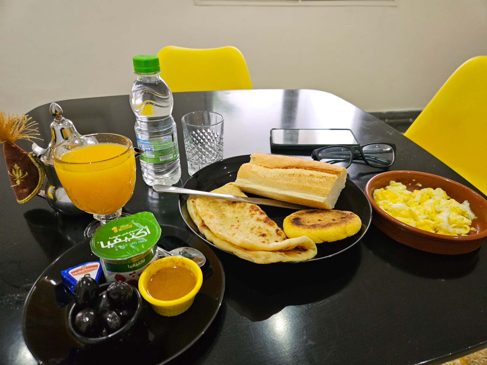 Traditional Moroccan breakfast with breads, eggs, olives and orange juice